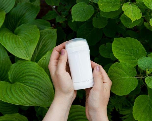 a deodorant tube on a green leafy background