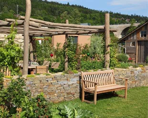 rustic pergola in a garden with a bench